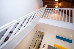 A staircase with white railings leading to a second floor.