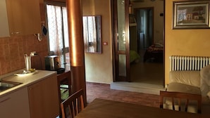A kitchen with a sink, a stove, and a window. There is a door leading to a bedroom. - Ca' Le Rose (Bagnolo San Vito)