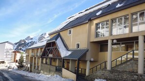 Un hôtel doté d’un télésiège, entouré de paysages enneigés et avec des montagnes en toile de fond.