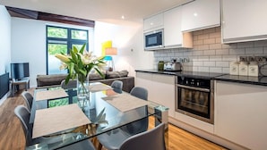A modern kitchen with white cabinets, a microwave, and a built-in oven. - The Wolsey at 52 Old Elvet (Durham)