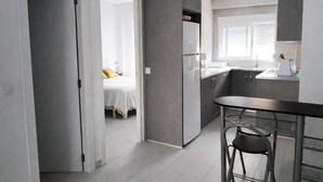 Una cocina moderna con refrigerador, pileta y taburetes de bar.