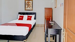 Een hotelkamer met een bed, een bureau en een kledingkast.