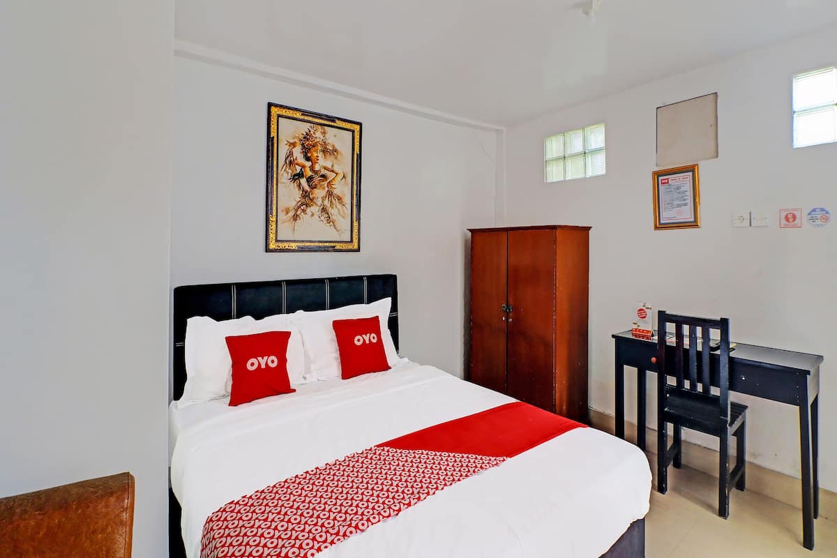 Une chambre d’hôtel comprenant un lit, un bureau, une chaise et une armoire.