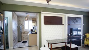 A modern kitchen with a built-in oven, a dining area with a glass table, and a yellow armchair. -  Beautiful sea view Apt,in the heart of Alexandria (alexandria)
