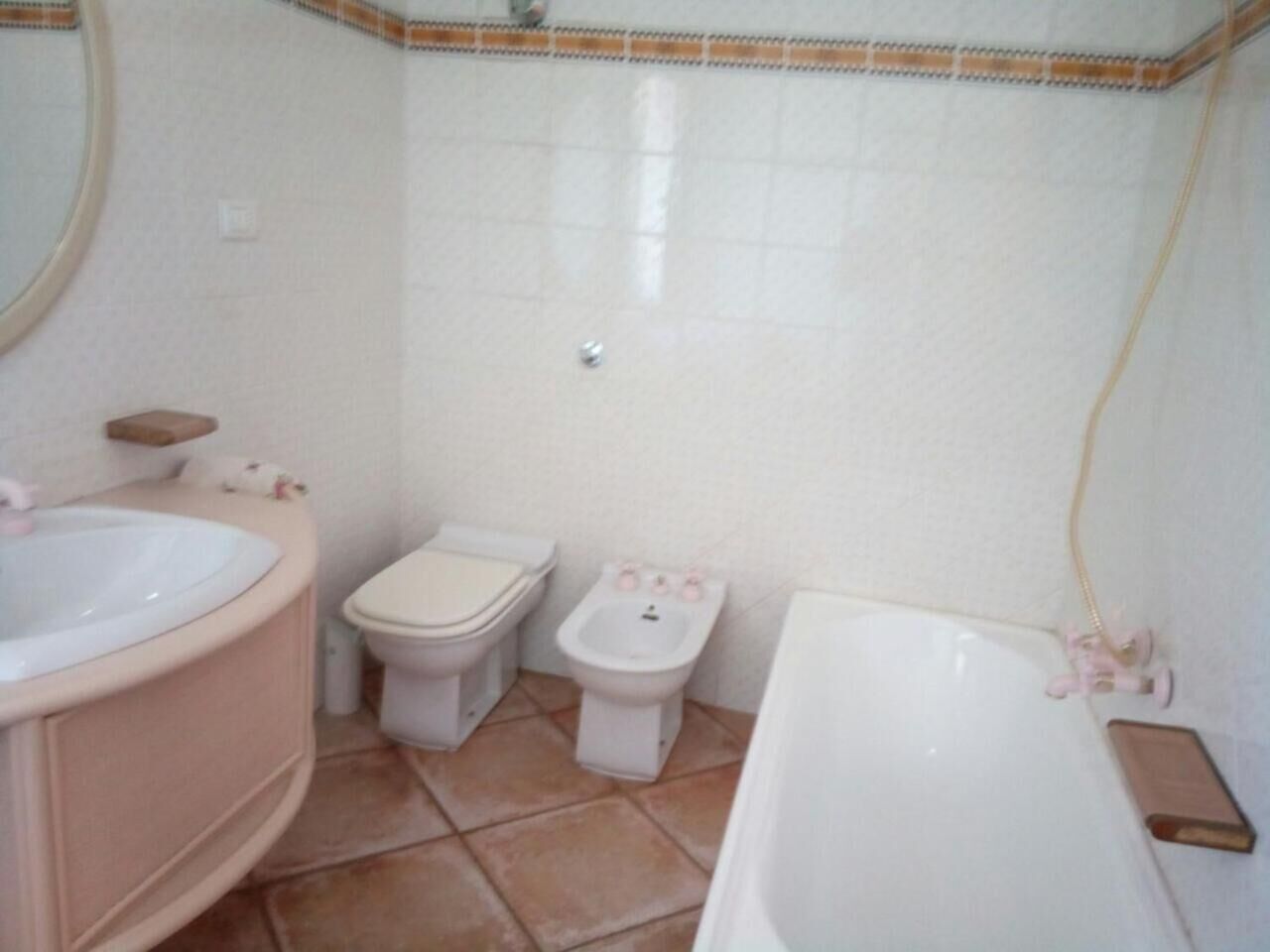 A bathroom with a sink, toilet, bidet, and bathtub.