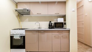 A compact kitchen with a stove, microwave, and sink. - Akacfa 57 Apartment II. (Budapest)