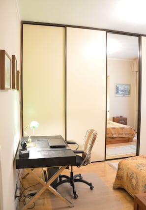 Cozy retreat with a single bed, desk, and chair, featuring a sliding door to a bathroom.