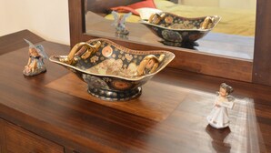 A wooden dresser with a large mirror, a decorative bowl, and a figurine. - Bajcsy 1 Apartment (Budapest)