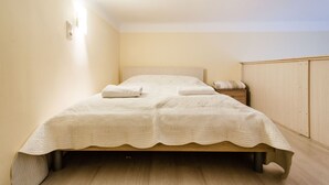A small, neatly arranged bedroom with a single bed, a nightstand, and a wardrobe. - Balassi 27 Apartment (Budapest)