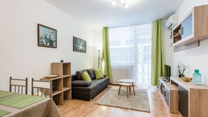 Una sala de estar moderna con sofá, mesa de comedor y televisor.
