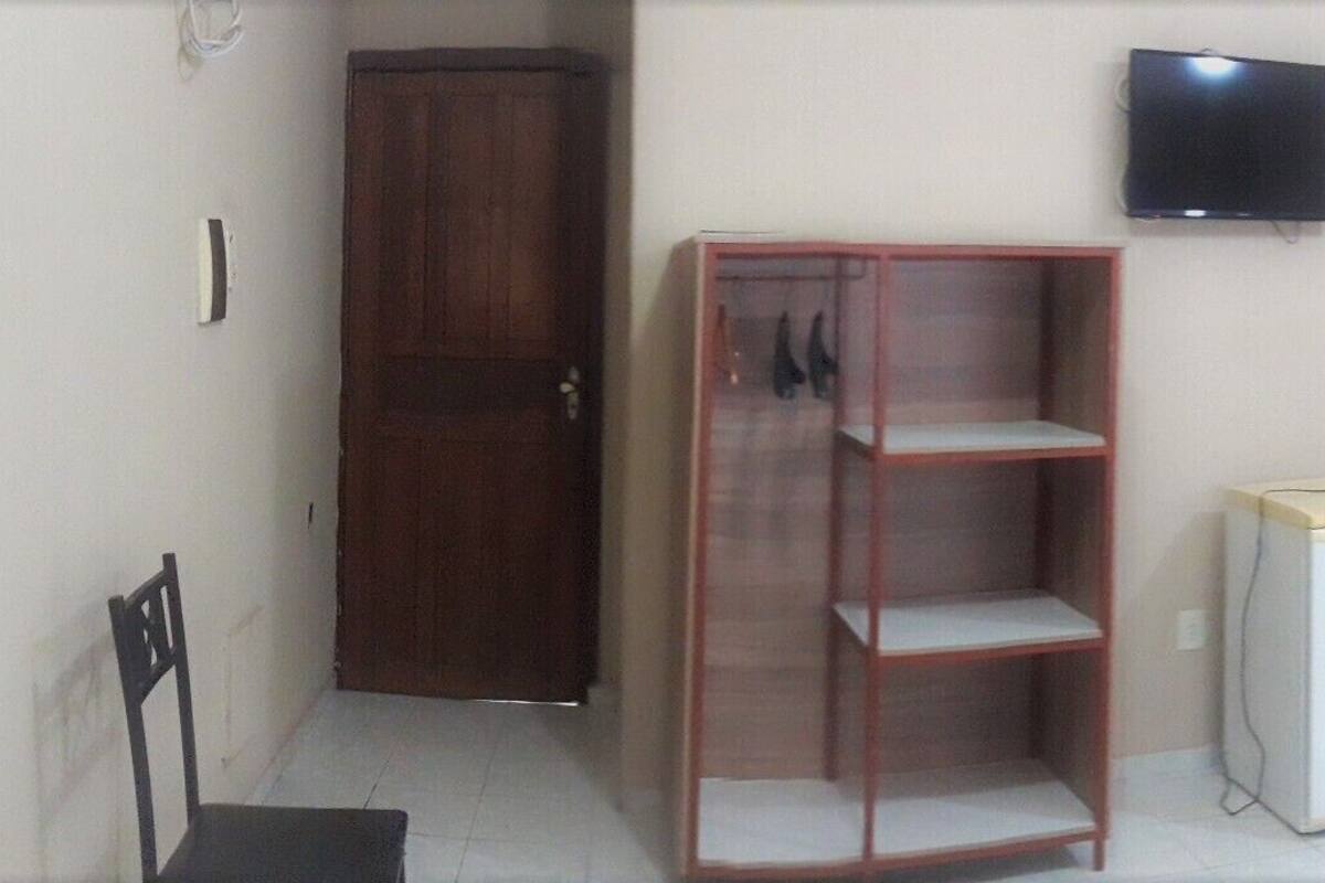 A hotel room with two beds, a television, a wardrobe, a small table, and a window with a view.