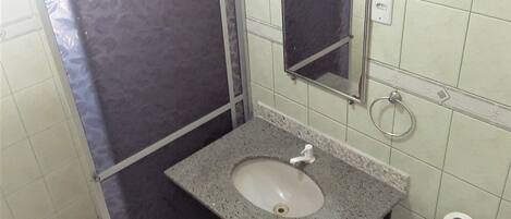 Un baño con lavamanos, inodoro y espejo.