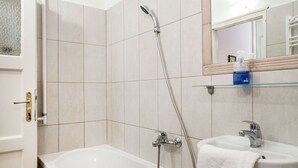 Moderni kylpyhuone, jossa on kylpyamme, pesuallas ja suihku.