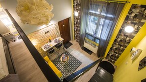 Eine moderne Küche mit Backsteinwand, ein Essbereich mit Tisch und Stühlen sowie eine Treppe, die zu einer anderen Etage führt.