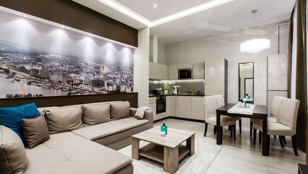 A modern living room with a sofa, coffee table, and dining area. - Klauzal 10 Apartment (Budapest)