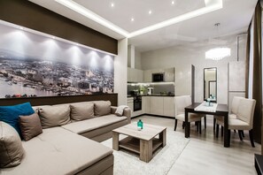 Een moderne woonkamer met een bank, salontafel en een eethoek.