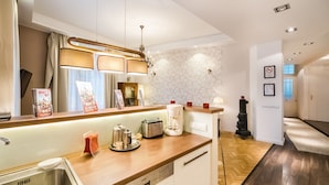 A modern kitchen with a wooden countertop, built-in dishwasher, and a coffee maker. - Magas 5 Apartment (Budapest)