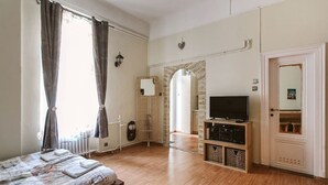 Un dormitorio con cama, televisor y armario.
