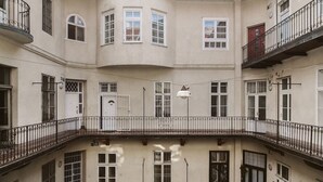 Un edificio de varios pisos con balcones, ventanas amplias y un patio central.