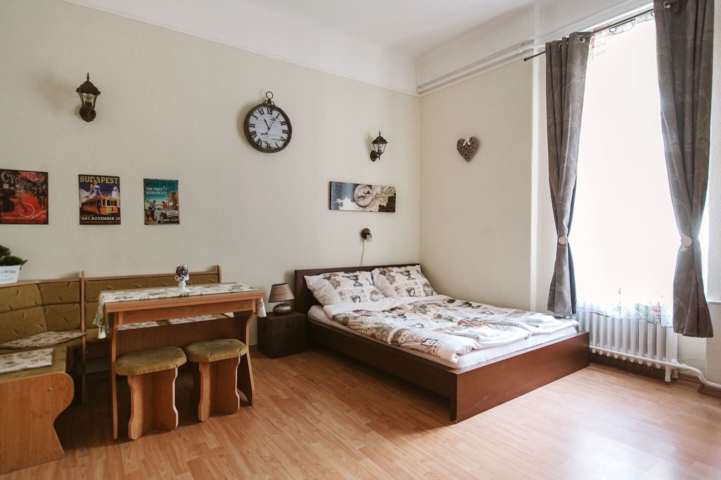 Ein gemütliches Zimmer mit einem hölzernen Bett, einem kleinen Schreibtisch mit Stuhl, einem Tisch und einer Heizung.