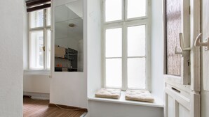 A room with a large window, a wooden floor, and a white wall. - O 40 Apartment (Budapest)