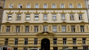 A multi-story building with a symmetrical facade, large windows, and decorative moldings. - O 40 Apartment (Budapest)