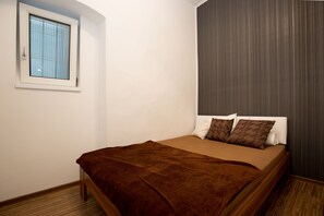 A bedroom with a bed, a window, and a curtain. - O 40 Apartment (Budapest)