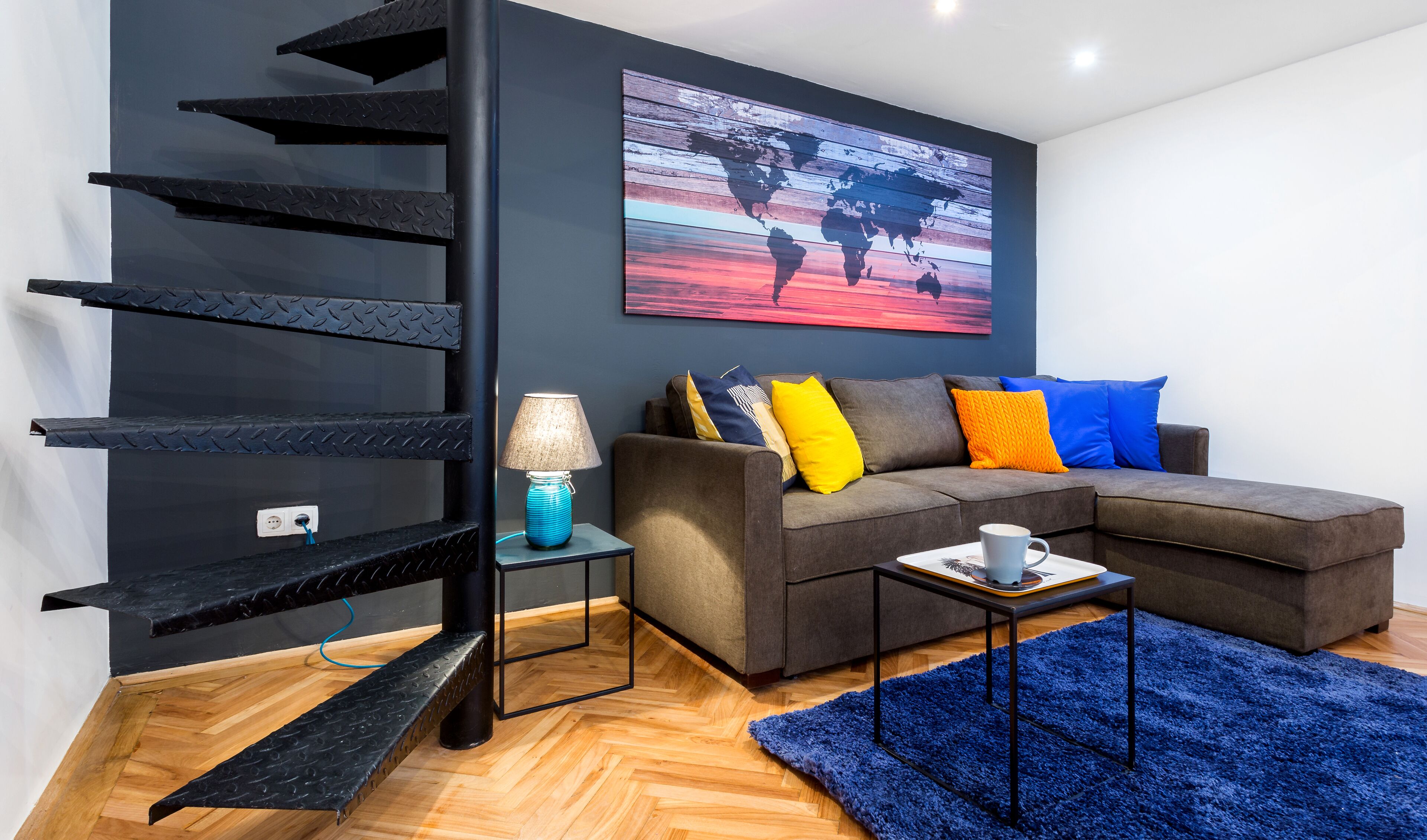 Ein modernes Wohnzimmer mit einem Ecksofa, einem Couchtisch, einer Lampe und einer Weltkarte als Wandkunst.