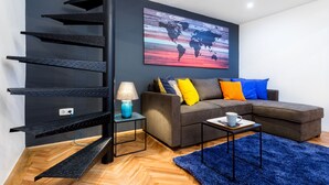 A modern living room with a sectional sofa, a coffee table, a lamp, and a world map artwork on the wall. - Oktober 6 6 Apartment (Budapest)