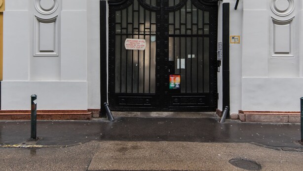 A building with a large black gate, white columns, and arched windows. - Paulay 7 Apartment I. (Budapest)