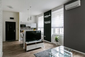 Relax in this stylish living room with a flat-screen TV, coffee table, and comfortable seating area.