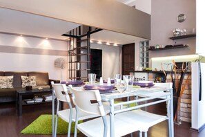 Una sala moderna con comedor, una escalera y una cocina.