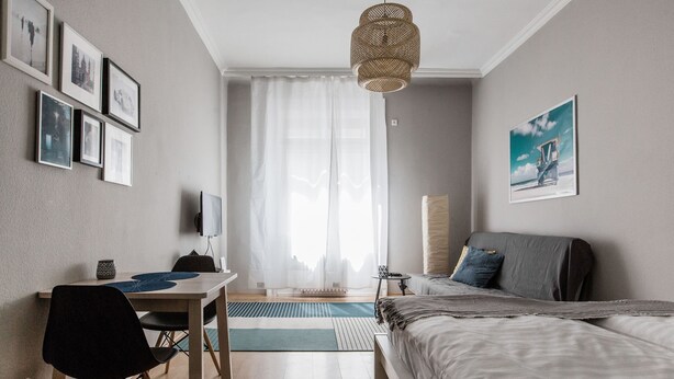 Un dormitorio moderno con cama, escritorio y silla.