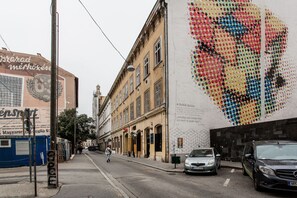 A street with buildings, a pedestrian, and parked cars. - Rumbach 7 Apartment (Budapest)