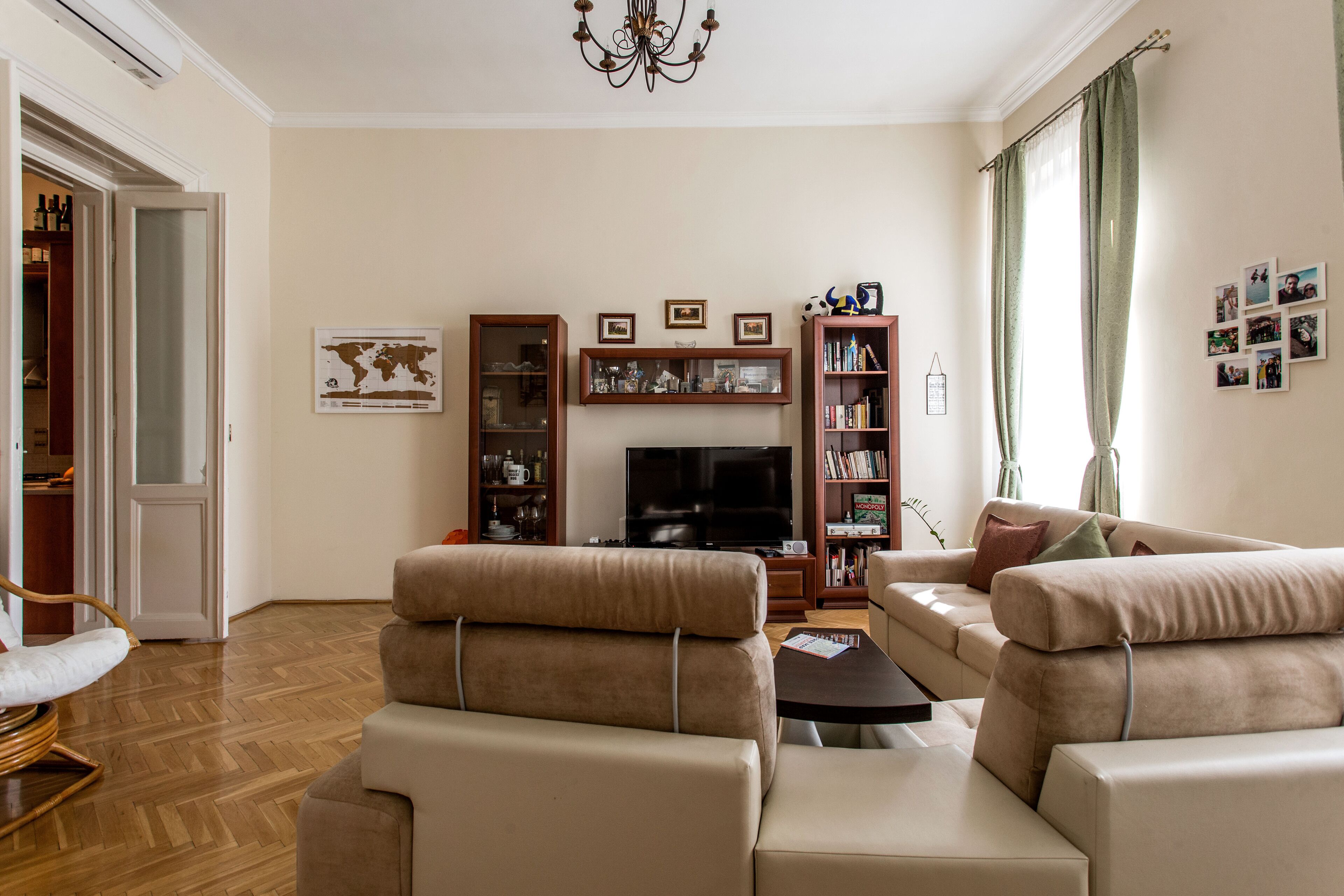 A living room with a sofa set, a television, and a bookshelf.