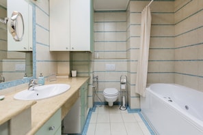 A bathroom with a sink, toilet, and bathtub.