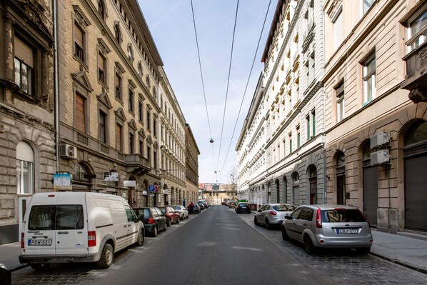 A street lined with parked cars and historic buildings.