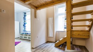 A staircase with wooden railings leading to an upper floor. A white door is visible on the right side of the staircase. - Vorosmarty 73 Apartment (Budapest)