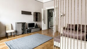 Una sala moderna con un sofá, un televisor, una estantería y un columpio.