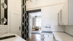 Una cocina moderna con armarios blancos, un lavamanos integrado y una araña.