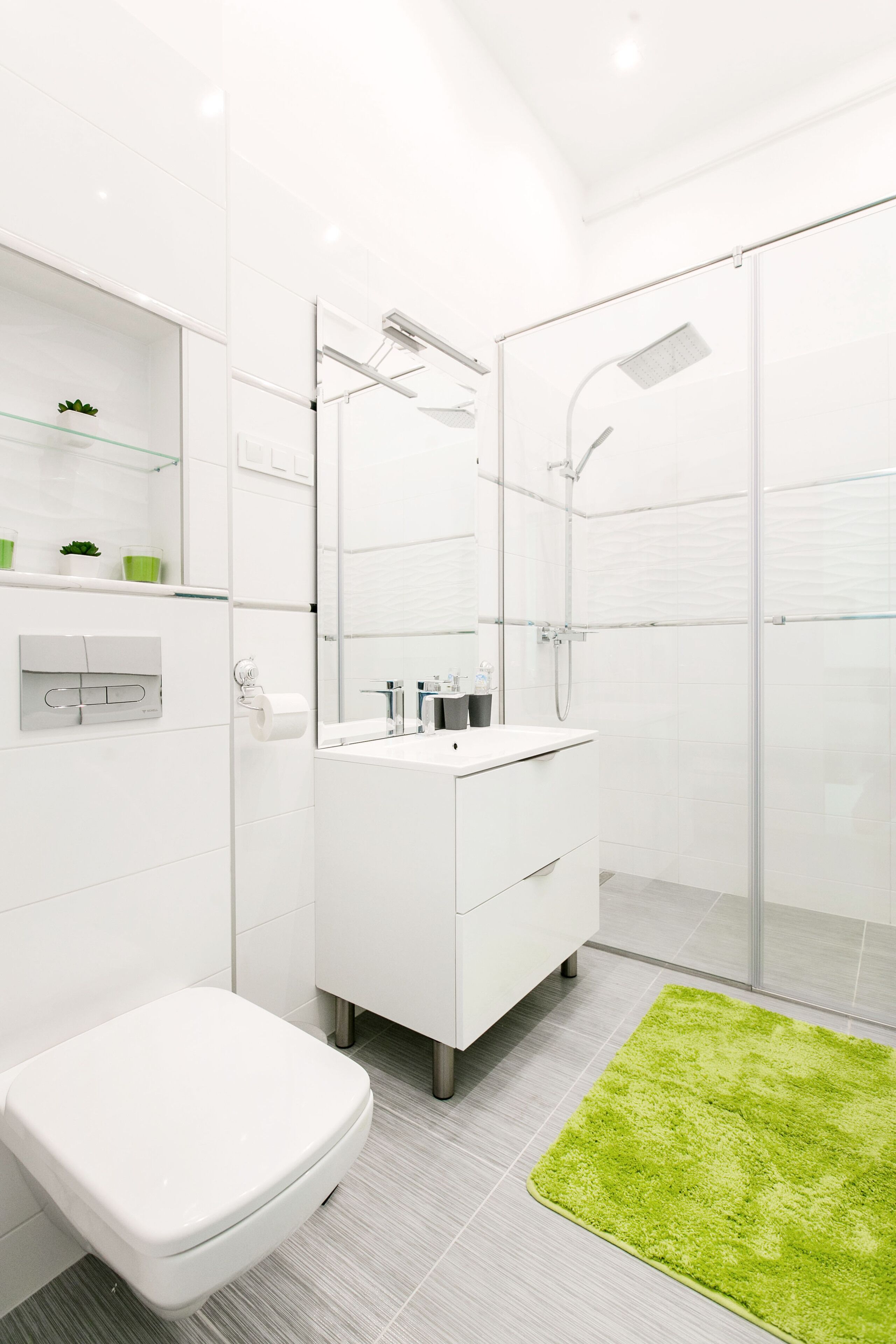 A modern bathroom with a toilet, sink, and shower.