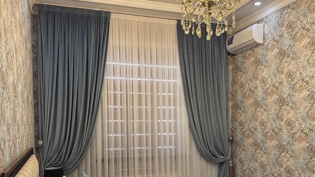 A bedroom with a large bed, draped curtains, a chandelier, and a patterned wallpaper. - Art Apart Hotel (Tashkent)