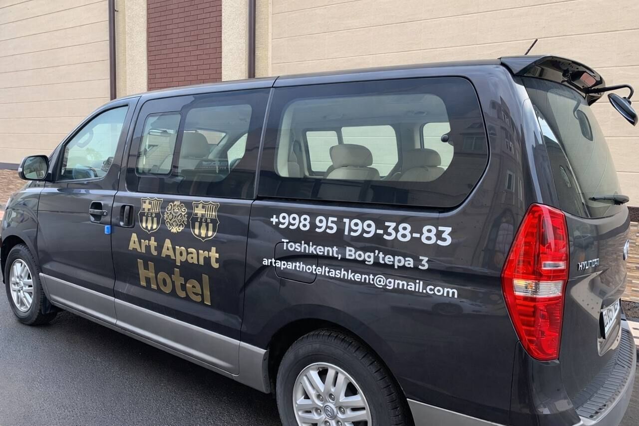 A black van with "Art Apart Hotel" and contact information on its side.