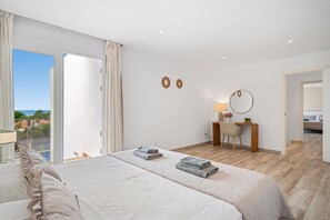 A bedroom with a large bed, a desk, and a view of the sea. - Villa Sunrise · Villa Sunrise ❤️ Seaviews ❤️ big, modern, AC (San Jaime Mediterráneo)