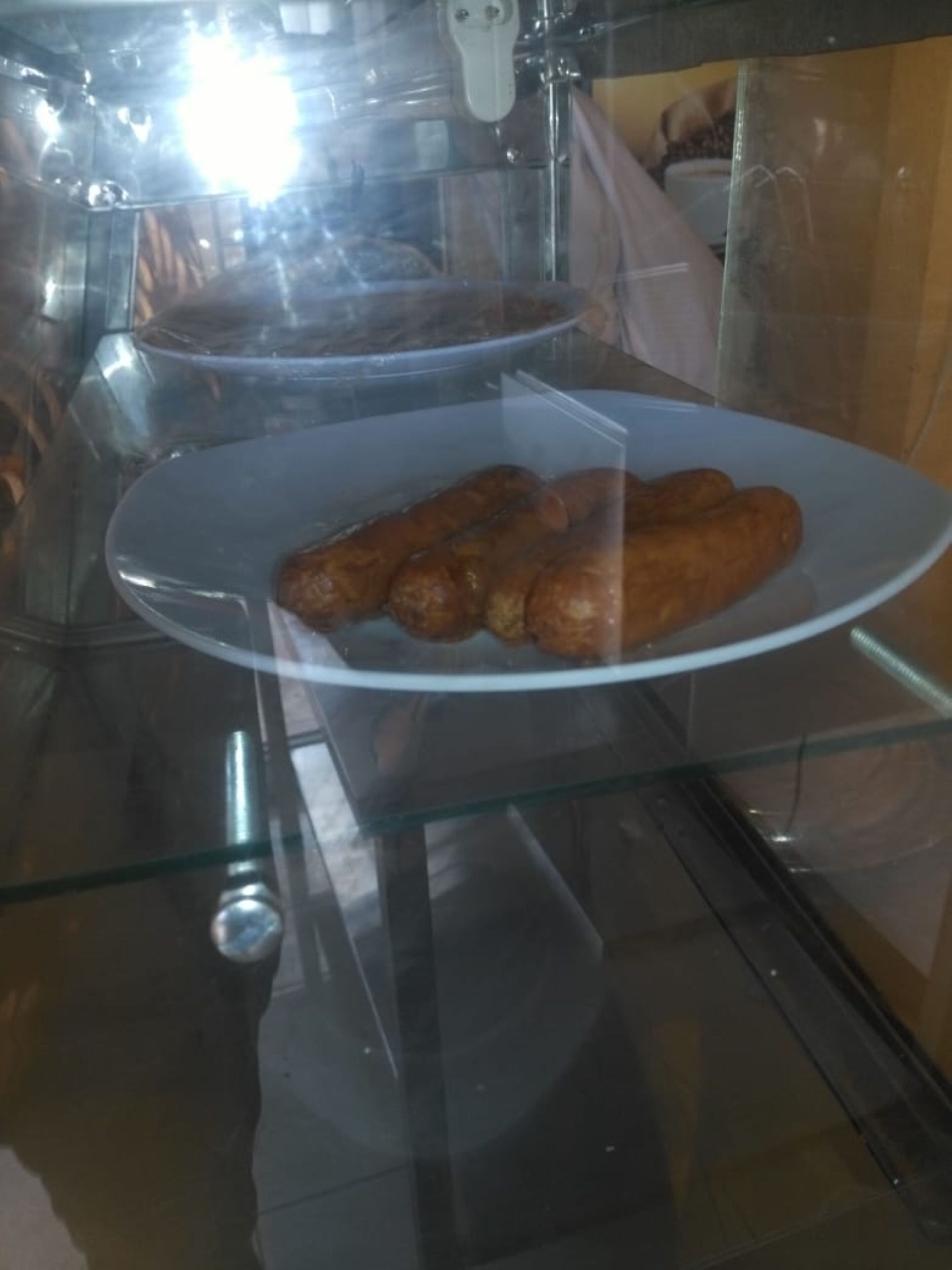 Una vitrina de vidrio con una bandeja de pasteles.