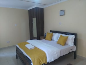 Une chambre à coucher avec un lit, une armoire et une petite table de chevet.