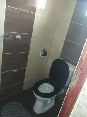 Une petite salle de bain comprenant des toilettes, un bidet et un espace douche.