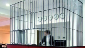 A reception area with a red counter and metal railing, featuring a clock and a small desk. - Alcatraz am Japanischen Garten (Kaiserslautern)