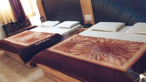 Dos camas con cubrecamas estampados en una habitación de hotel.