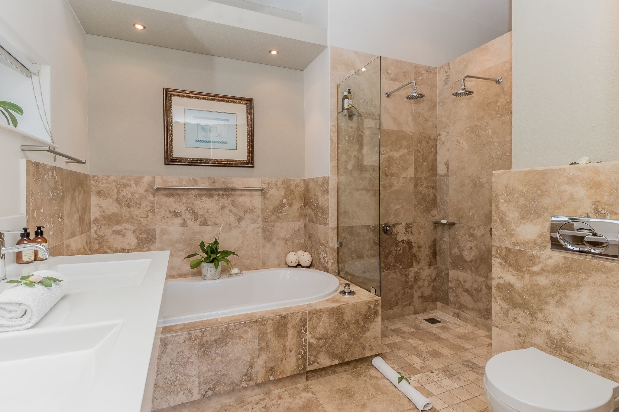 Une salle de bain moderne avec une baignoire sur pieds, une douche à parois de verre et des toilettes.